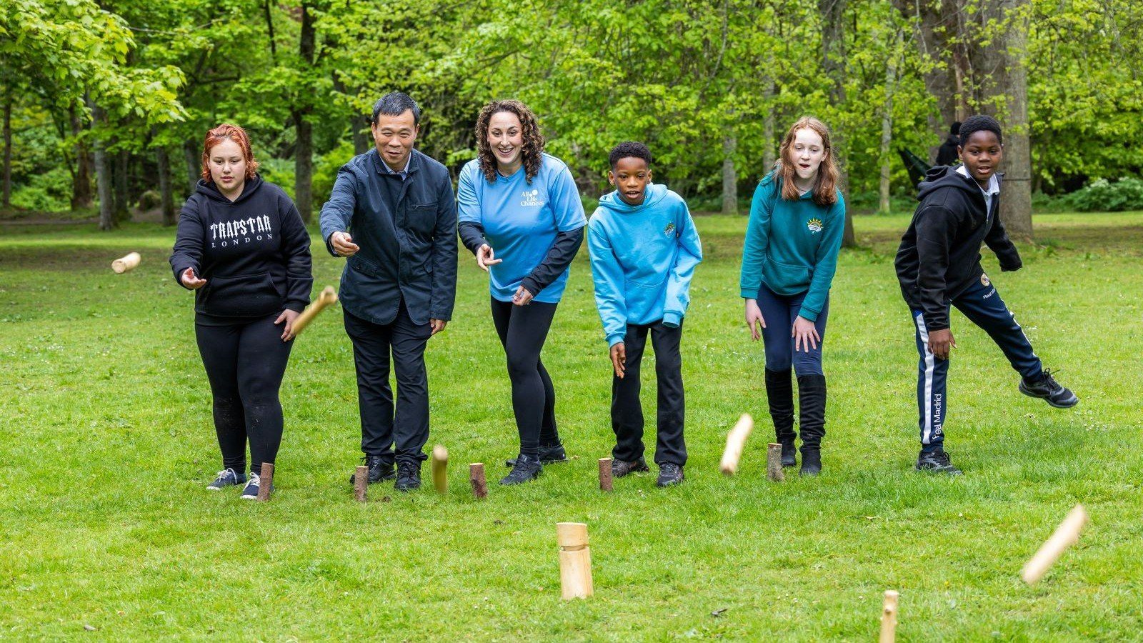All Life Chances & Fireflies – Mr Baoshan Lu, CNOOC International enjoys a game of the stick game Kubb with young people and Lara Munro, All Life Chances