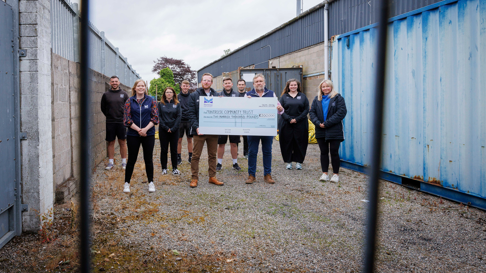 Standing with the £200,000 Cheque: Chris Platt (CEO of Montrose Community Trust), and Tom Hutchison (CEO of Montrose Port) surrounded by Montrose Community Team and Catriona Innes of Montrose Port.