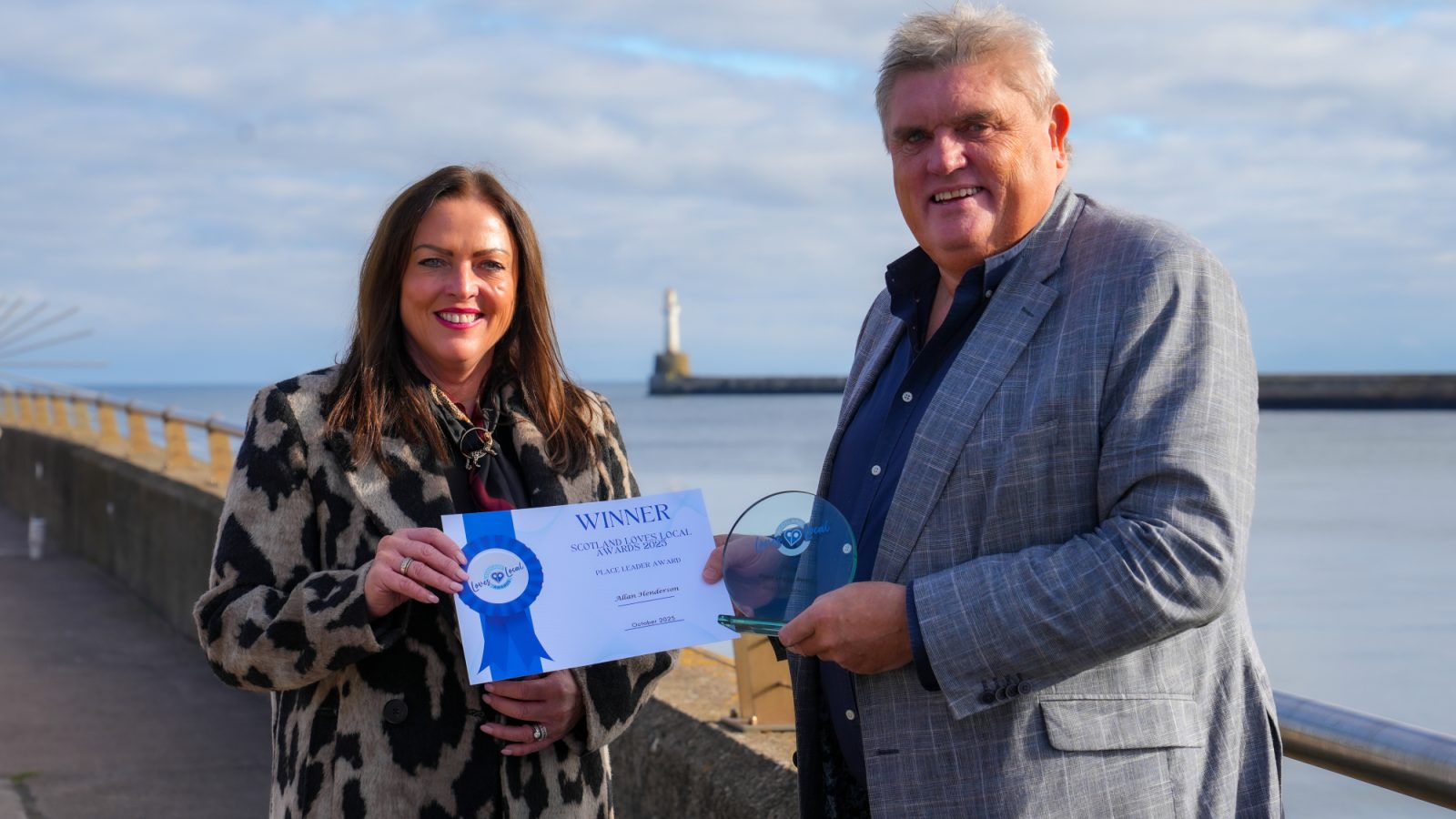 Allan Henderson receiving his Scotland Loves Local Place Leader Award from Scotland’s Towns Partnership chief officer Kimberley Guthrie