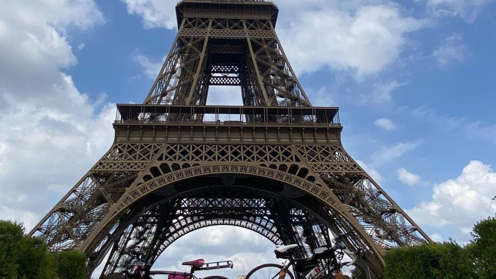 Paris Cycling Duo Sarah and Katy lift their bikes in celebration at the Eiffel Tower  L–R: Sarah McKechnie, Katy Townhill