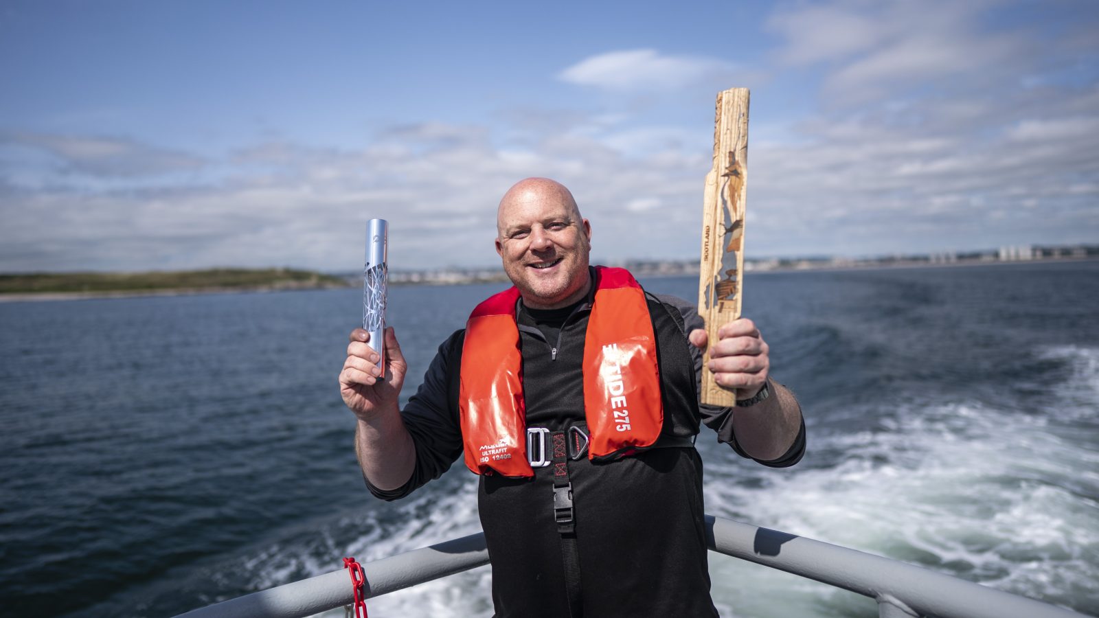 Mark Williams, Chief Operating Officer, Denis Law Legacy Trust with the King’s Baton and replica Queen’s Baton from 2014