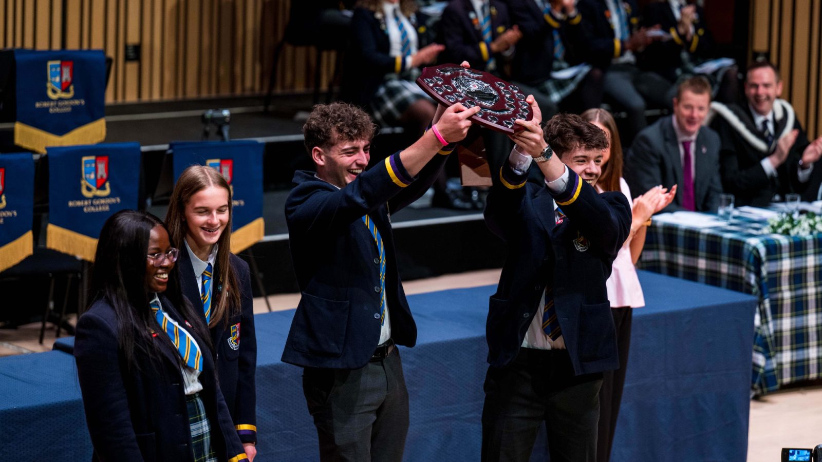 RGC pupils Kemi Catriona Harry and Christian proudly accepting the John Reid Shield on behalf of Blackfriars House at Senior Prize Giving