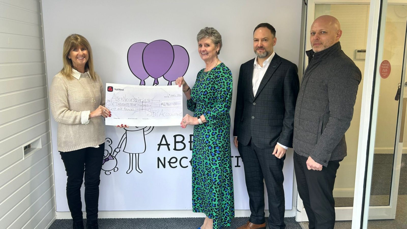 Sandra Stephen, Stuart Beaton, and Stephen Glanas from SBP present the donation check to Michelle Herd, Co-Founder and CEO of AberNecessities